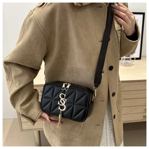 Detail of black quilted leather crossbody bag with gold SS logo and stylish wide strap