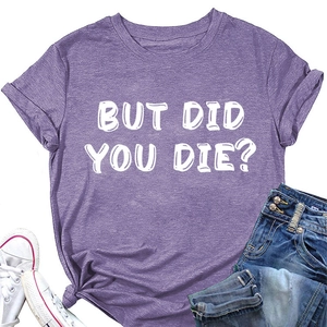 Dettaglio flat lay di una maglietta viola con scritta bianca BUT DID YOU DIE