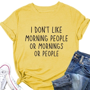 Flat lay of yellow cotton T-shirt with 'I DON'T LIKE MORNING' slogan and rolled sleeves
