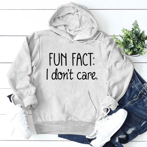 Vue à plat d'un sweat à capuche gris avec texte Fun Fact sur plancher en bois blanc