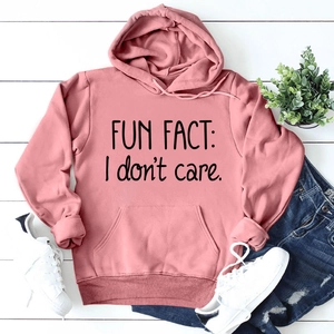 Détail du sweat à capuche rose avec poche kangourou et poignets côtelés sur bois