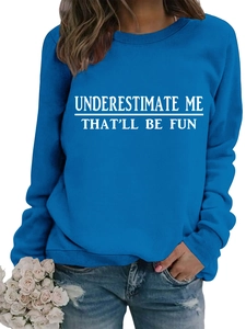 Dettaglio felpa blu con stampa slogan 'Underestimate Me' bianca e polsini a costine