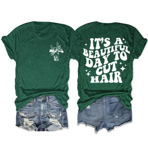 Détail du t-shirt vert foncé avec l'imprimé 'IT'S A BEAUTIFUL DAY TO CUT HAIR' au dos