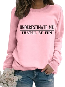 Dettaglio della felpa rosa con scritta Underestimate Me e polsini a coste su modella