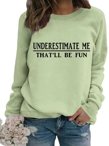 Dettaglio felpa verde chiaro con stampa Underestimate Me That'll Be Fun sul petto