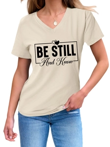 Detail of V-neck beige t-shirt featuring 'BE STILL And Know' printed graphic text