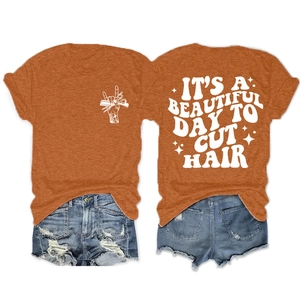 Vue à plat d'un T-shirt orange avec impression de barbier au dos et détails graphiques