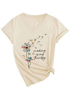Détail du t-shirt beige à col en V avec imprimé pissenlit-livres et ourlet noué chic