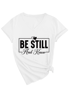 Detail of V-neck white T-shirt featuring Be Still and Know print with side knot styling