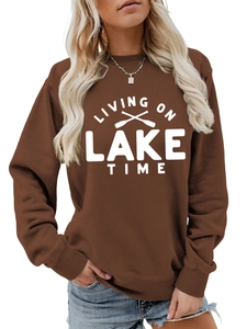 Detail of dark brown crewneck sweatshirt with white Living on Lake Time graphic print