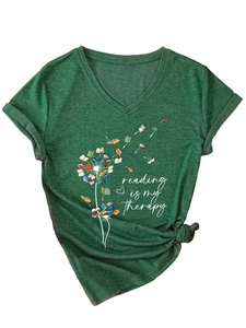 Détail d'un t-shirt col V vert forêt avec imprimé pissenlit en livres et lettrage