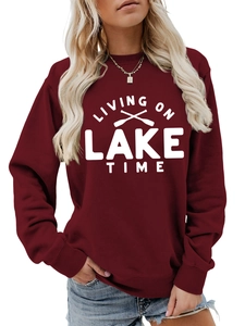 Detail of burgundy sweatshirt showing 'LIVING ON LAKE TIME' print and ribbed cuffs
