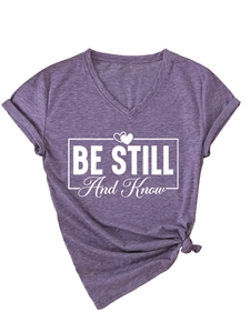 Detail of V-neck heather purple t-shirt featuring Be Still and Know graphic print