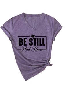Detail of purple V-neck T-shirt with side knot and BE STILL And Know slogan print