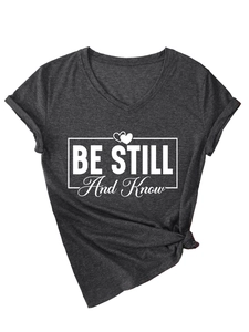 Detail of V-neck grey tee with Be Still And Know graphic and side knot design