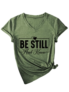 Detail of army green V-neck T-shirt showing knotted hem and 'BE STILL And Know' print