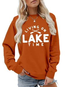 Detail of orange crewneck sweatshirt with white Living on Lake Time print and oars