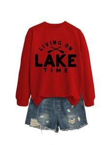 Flat lay of red Living on Lake Time sweatshirt with distressed denim shorts