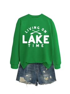 Detail view of a bright green sweatshirt featuring Living on Lake Time text and oars print