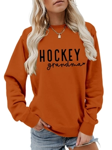 Détail du sweat orange avec texte HOCKEY grandma et motif graphique de cœur