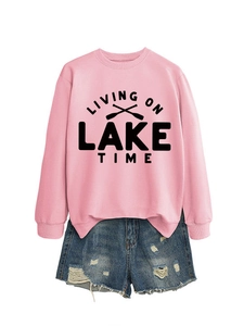 Flat lay of pink sweatshirt with Lake Time print and distressed denim shorts