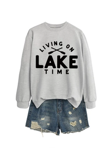Close-up of Living On Lake Time crewneck sweatshirt with distressed denim shorts