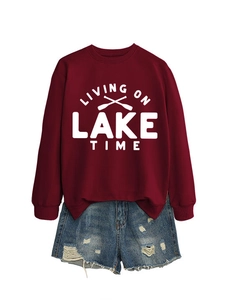 Flat lay of maroon long sleeve sweatshirt with Lake Time print and distressed denim shorts