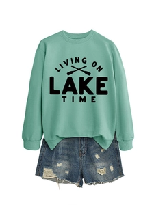Detail view of mint green sweatshirt featuring Lake Time print and oars on white background