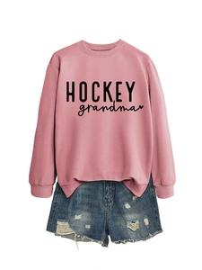 Détail de l'imprimé noir HOCKEY grandma et du motif de cœur sur le sweat-shirt rose