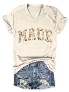 Flat lay of beige V-neck T-shirt with floral letter print and frayed blue denim shorts