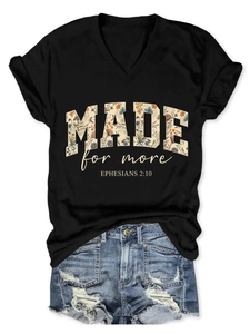 Flat lay of black V-neck T-shirt with MADE for more floral text and denim shorts