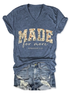 Flat lay of navy V-neck T-shirt with Made for More print and distressed denim shorts