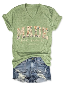 Detail of V-neck green heather T-shirt featuring floral MADE FOR MORE graphic print