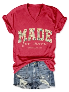 Detail of red V-neck T-shirt with floral MADE for more graphic print and rolled sleeves