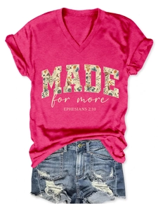 Flat lay of pink V-neck T-shirt with flower lettering and ripped denim shorts