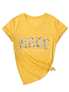 Detail of warm yellow V-neck T-shirt with floral MADE text and tied hem knot design