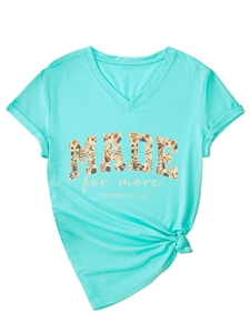 Detail of mint green V-neck T-shirt with 'MADE for more' floral print and knot hem design