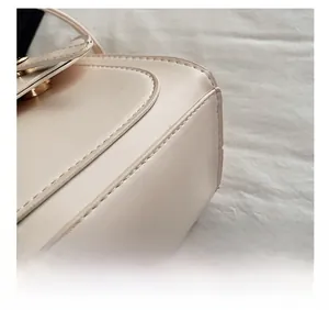 Macro shot of precise stitching and smooth leather edge on beige crossbody handbag