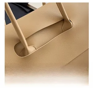 Detail shot of the reinforced handle stitching on a beige leather tote handbag