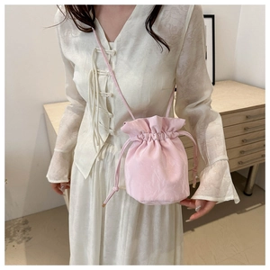 Close-up of pink drawstring bucket bag with textured fabric shown on a model