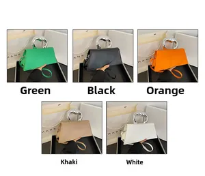 Detail view of stylish handbag with liquid metal handles in green black orange khaki white
