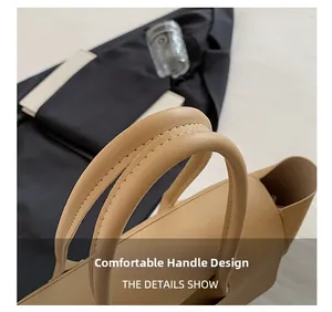 Detail of comfortable carry handles with reinforced stitching on a beige leather tote bag