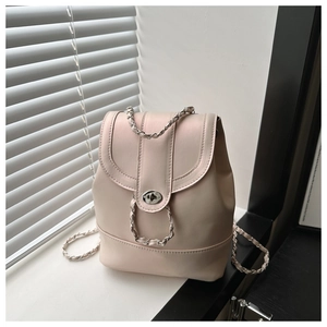 Détail du sac à dos en similicuir rose avec bretelles en chaîne et fermoir tournant