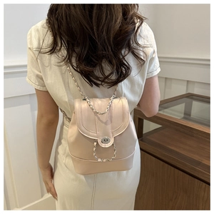 Detail of pink iridescent mini backpack featuring a metal twist lock and chain strap