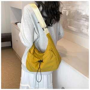 Detail of mustard yellow nylon tote bag with adjustable contrast wide shoulder strap