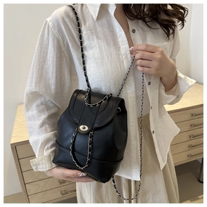 Detail of elegant black bucket bag featuring silver chain strap and metal twist-lock closure