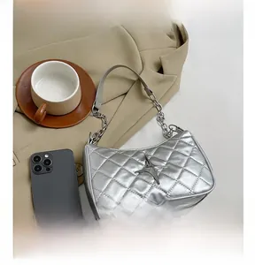 Detail of silver quilted shoulder bag featuring metallic star and elegant chain strap