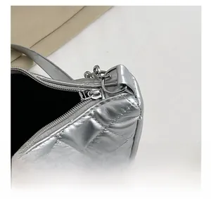 Detailed close-up of smooth silver zipper and hardware on a quilted rhombic chain bag