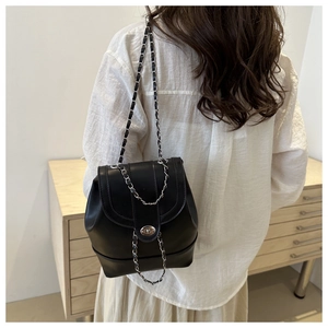 Détail du sac seau noir vintage avec bandoulière chaîne et fermoir rotatif métallique