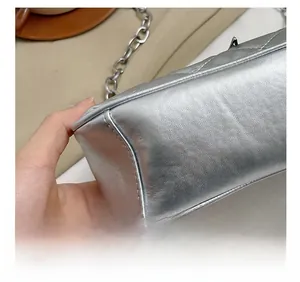 Macro detail of silver shoulder bag showing leather texture and precision stitching